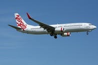 White and Red Qantas Airplane Fly High Under Blue and White Clouds