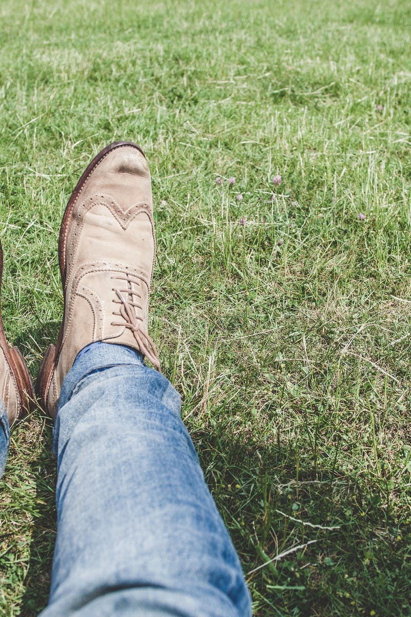 Person Wearing Blue Denim Jeans Sitting on Grass · Free Stock Photo