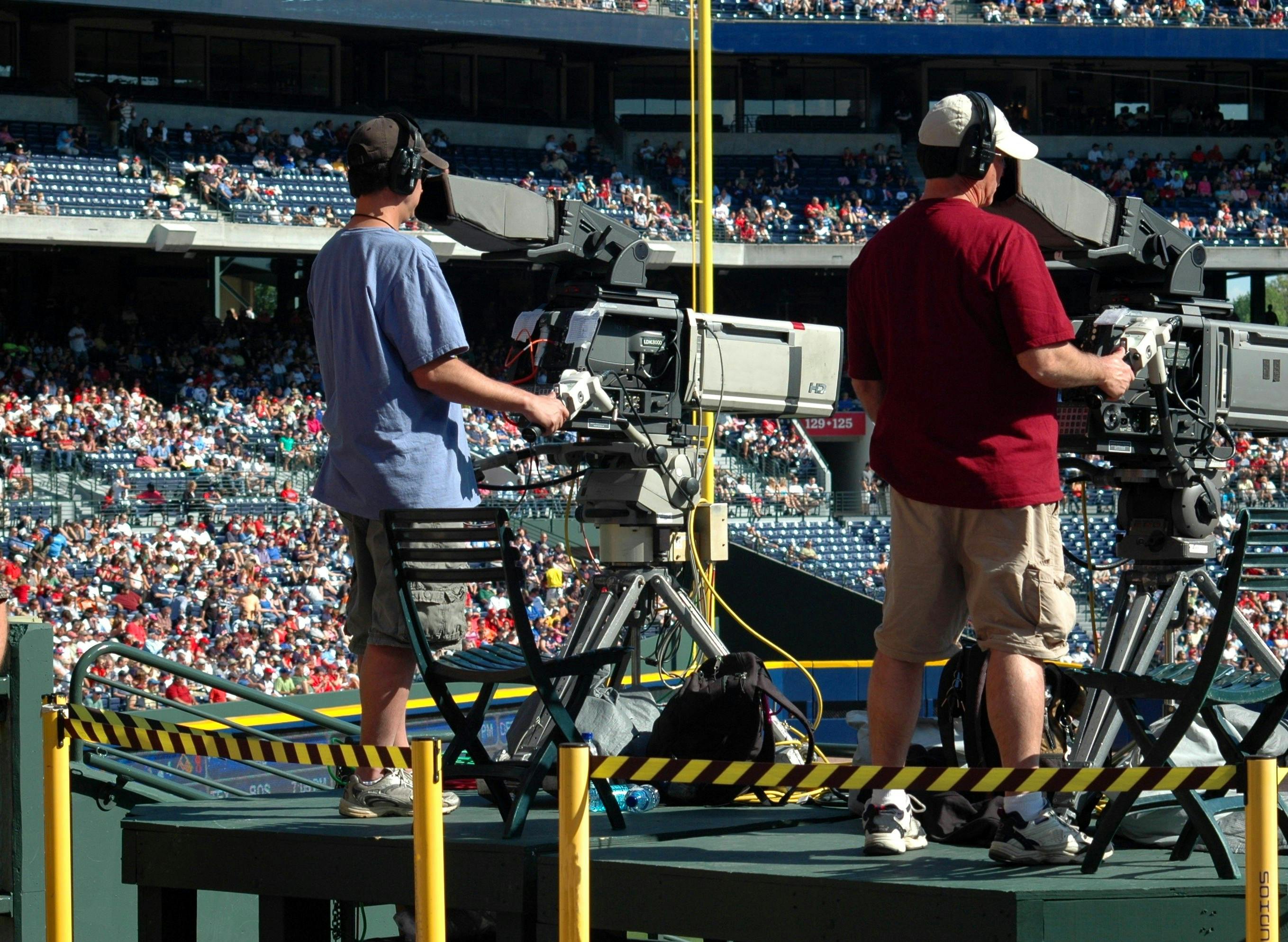 2 Camera Man Standing in a Green Metal Stage during Daytime · Free Stock Photo