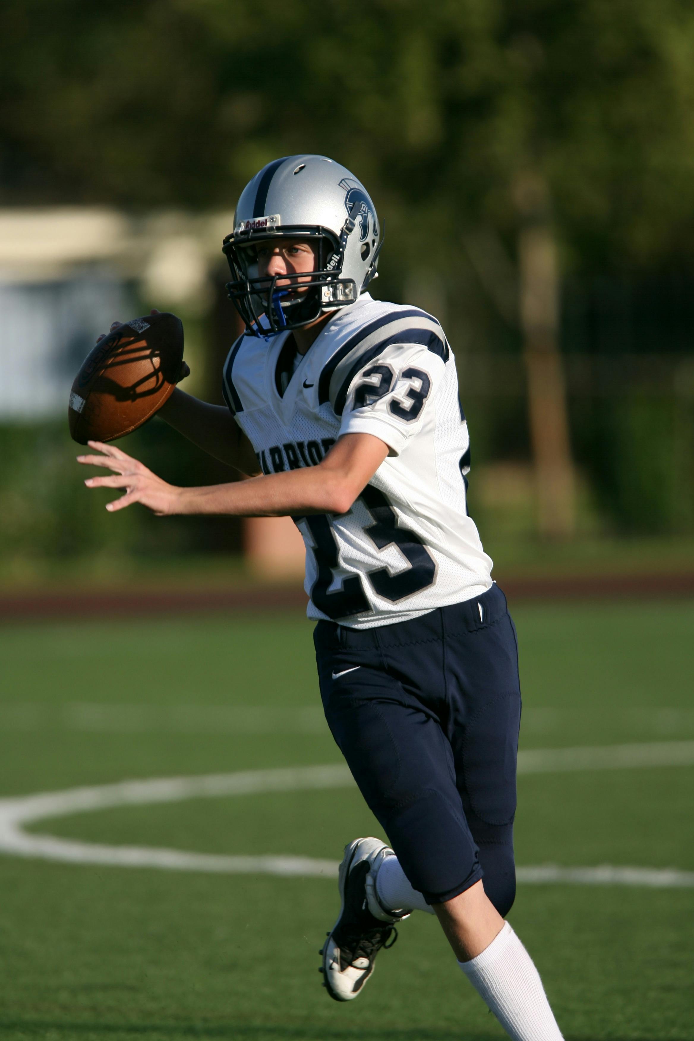 Man in White and Black Football Jersey Playing on Field during Daytime ...