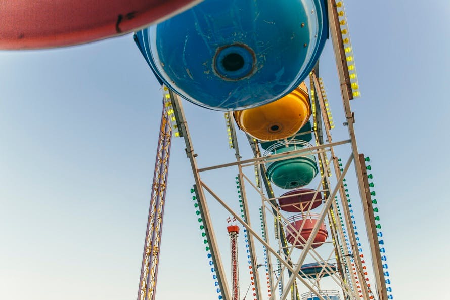 Low Angle Photo of Blue Yellow and Green Ferris Wheel