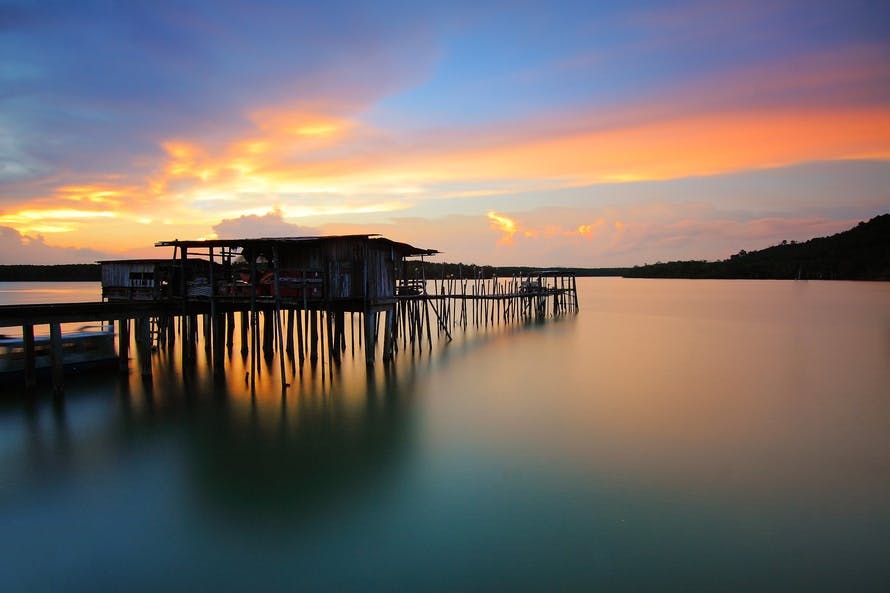 Wooden House in Body of Water during Sunset Photo