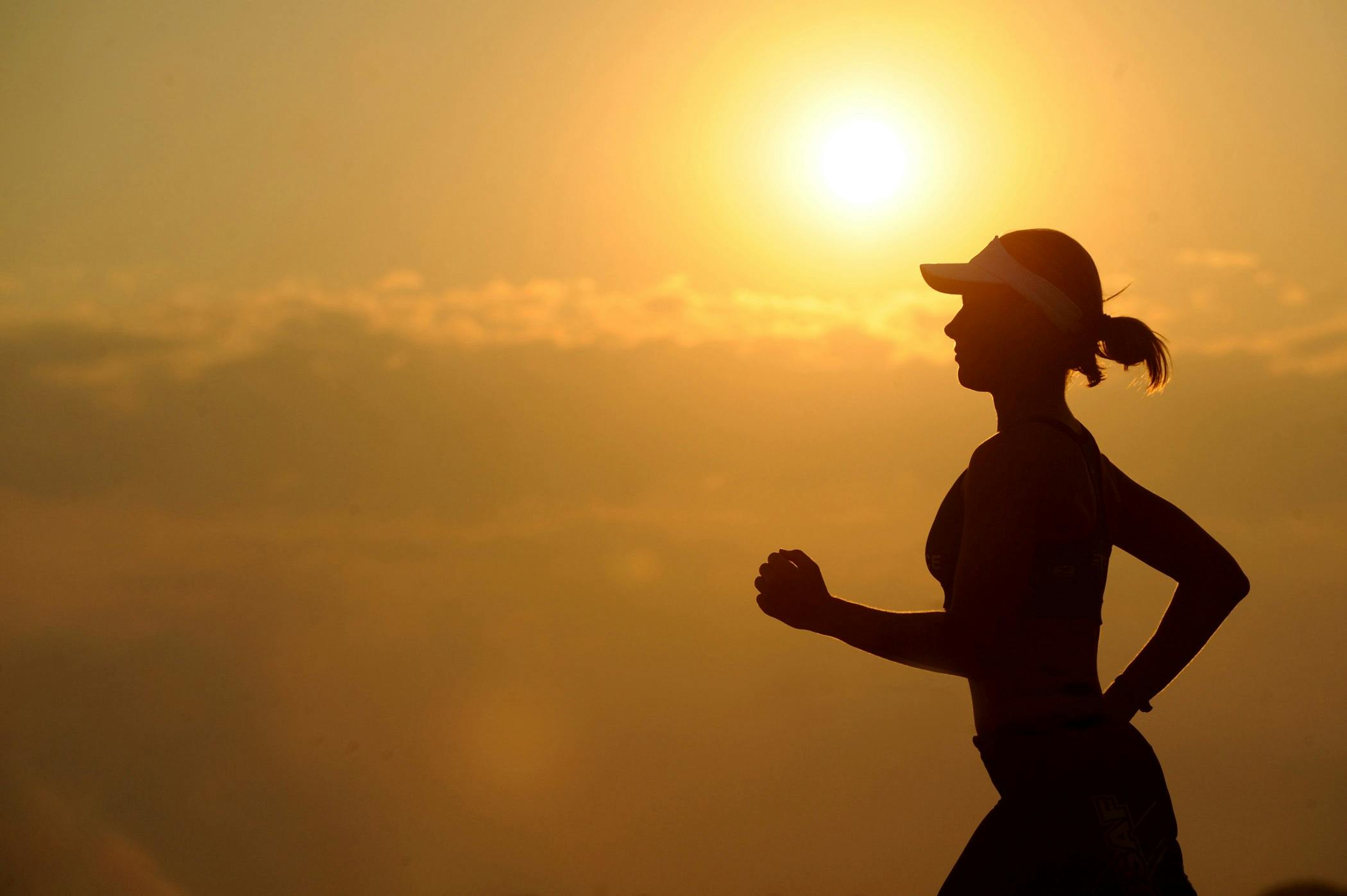 Woman exercising outdoors at sunset.