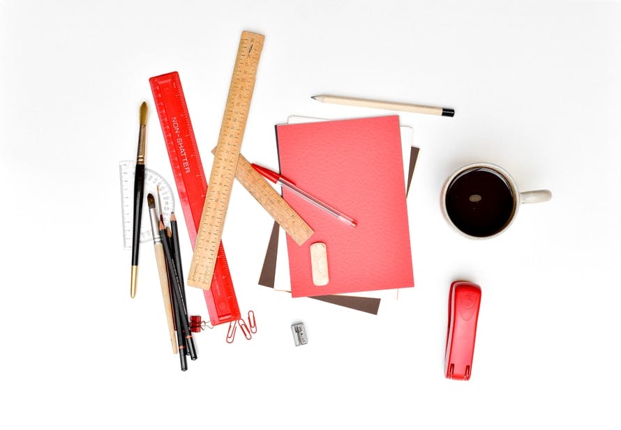 A collection of art supplies and a coffee cup.