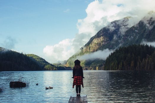 Girl Standing on Dock Facing the Wilderness