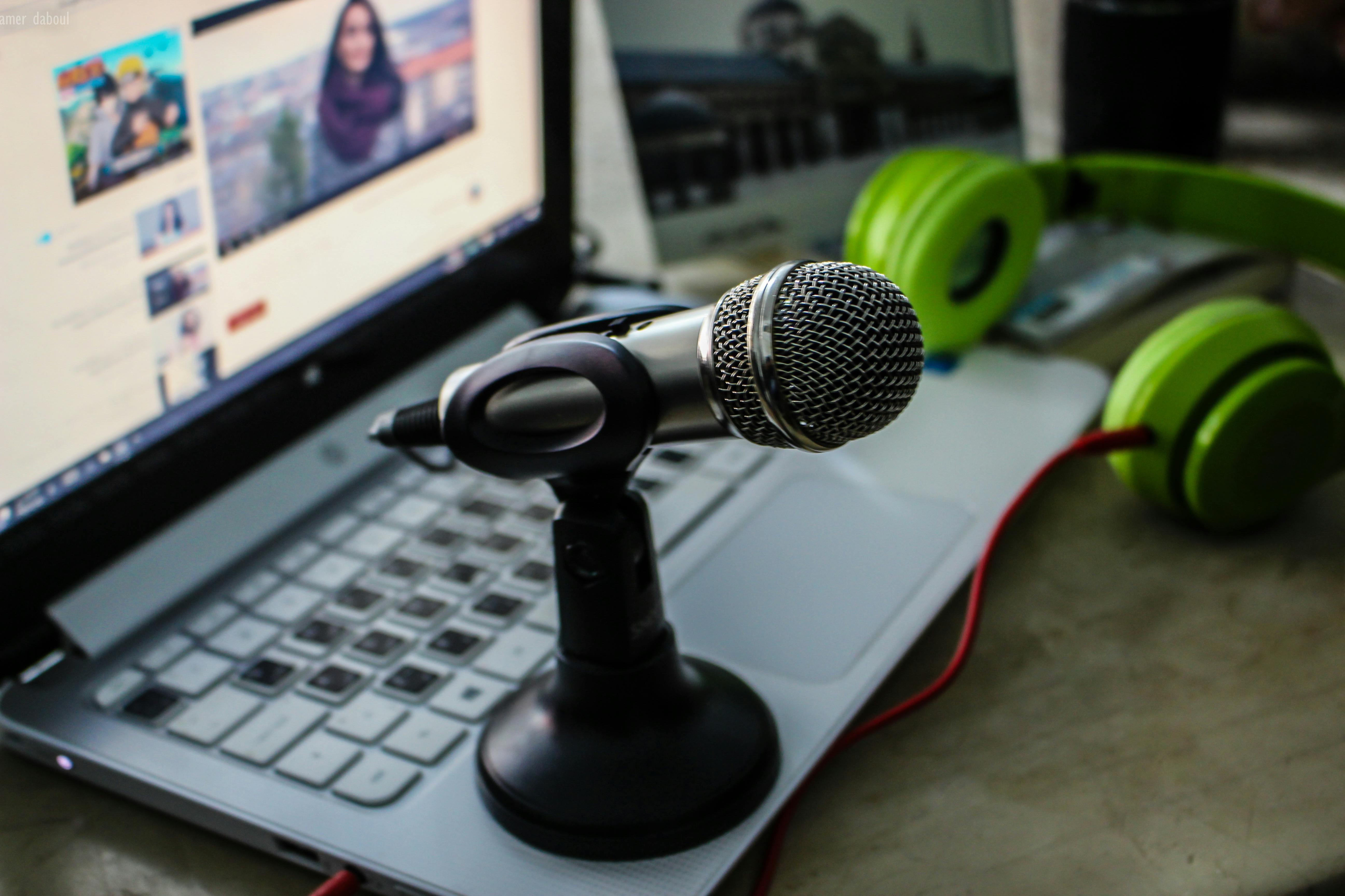 Green Headphones Near Laptop and Microphone · Free Stock Photo