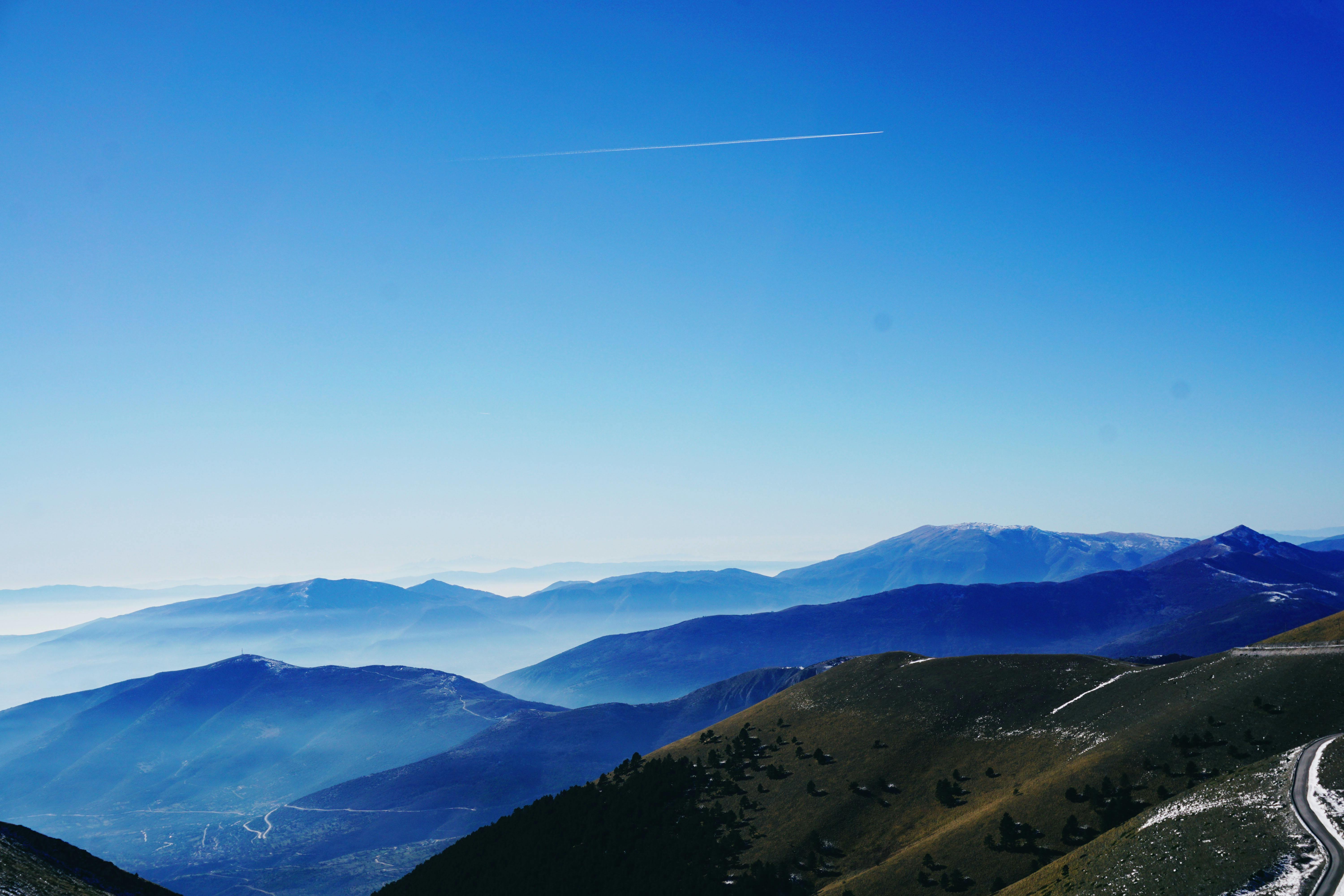 Green And Blue Fog Covered Mountains Under Blue Sky · Free Stock Photo
